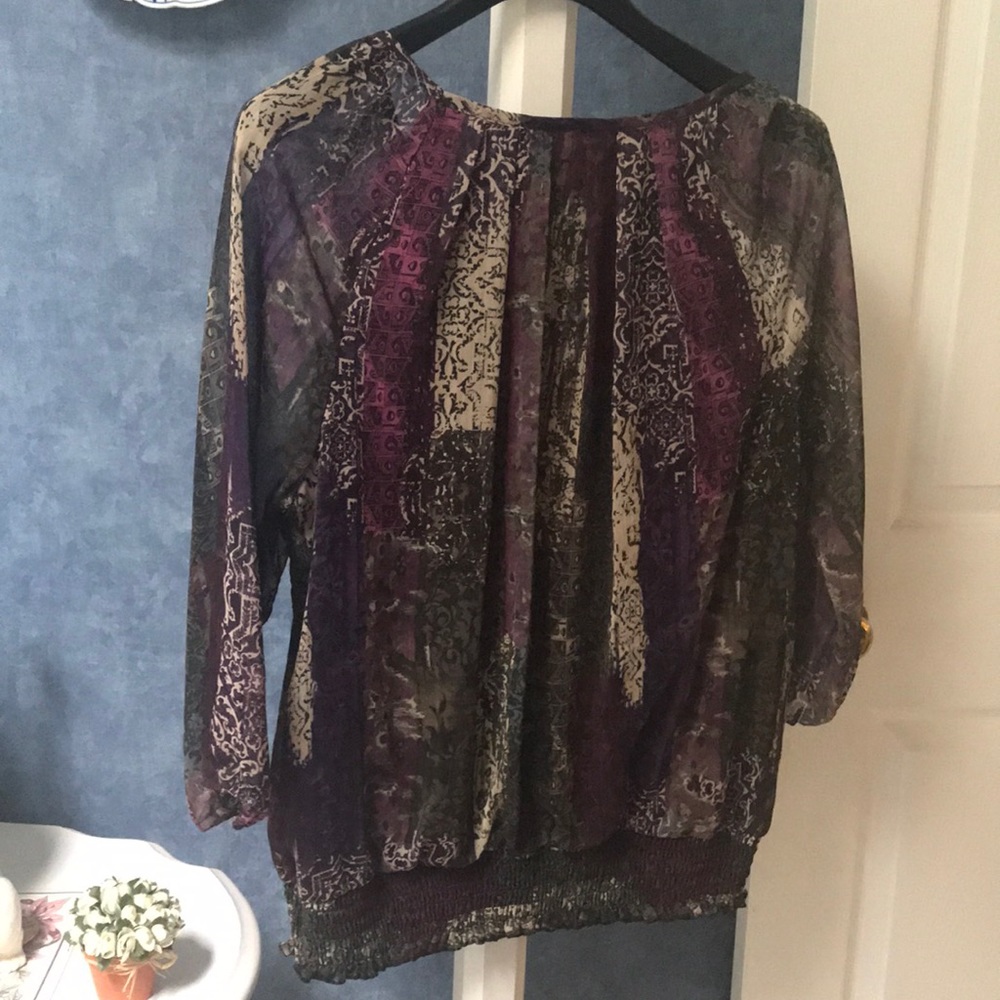Multi color top with purples greens cream colors .